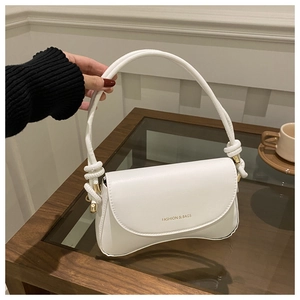 Detail of white leather shoulder bag featuring knotted handle and gold embossed logo