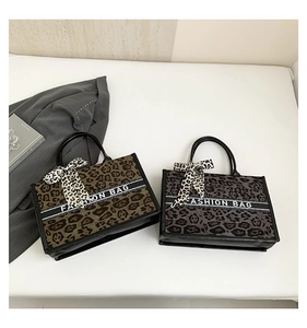 Détail à plat de sacs cabas léopard avec sangle à texte mode et rubans en nœud de soie