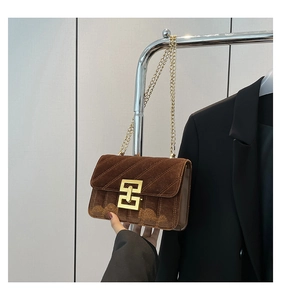 Détail du sac bandoulière en velours marron avec surpiqûres et chaîne dorée