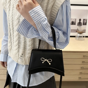 Chic black crossbody box bag with gold bow accent for women spring 2025 fashion