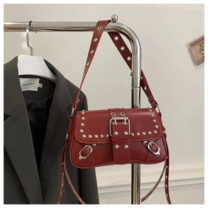 Close-up of red leather motorcycle baguette bag with silver studs and belt buckle detail