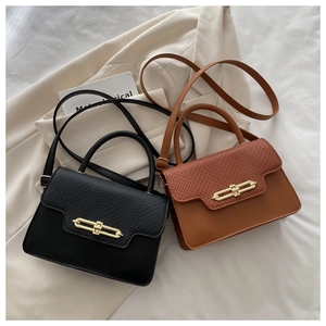 Chic black and brown crossbody bags with gold chain buckles on an elegant suit background