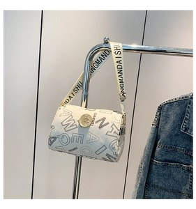 Detail view of white cylinder bag with black letter prints and wide fabric strap