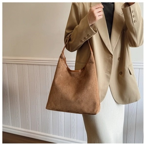 Detail of dark brown suede hobo bag texture and premium leather trim finish