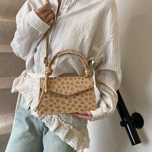 Sac à main beige en similicuir avec motifs floraux gaufrés et boucle métallique