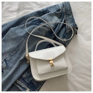 Detail of white faux leather crossbody bag with gold metal buckle and contrast stitching