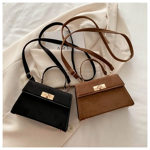 Detailed view of vintage matte leather crossbody bags in black and dark brown with gold clasps