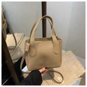 Detailed macro view of the beige lychee pattern leather texture and zipper of the bucket bag