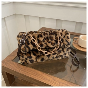 Detail of leopard print plush handbag featuring a brown strap and khaki plastic chain link