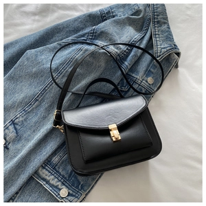 Detail of matte black leather bag featuring a gold buckle and elegant stitching
