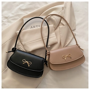 Detail showing the metal bow buckle and knotted strap on stylish crossbody bags