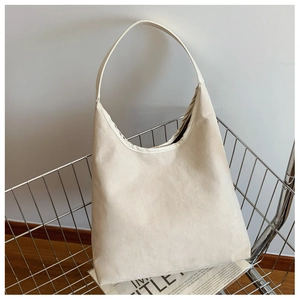 Detail of minimalist cream tote bag with textured canvas in a metal shopping basket