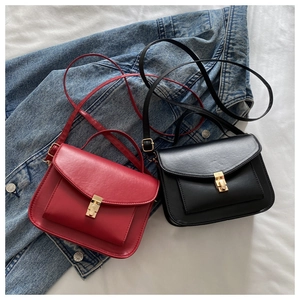 Close-up of small textured PU leather messenger bags with golden metal flip locks