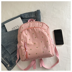 Close-up of light pink floral embroidery on water-resistant nylon fabric backpack
