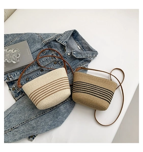 Detail of woven straw bucket bags with leather straps and stylish stripe patterns