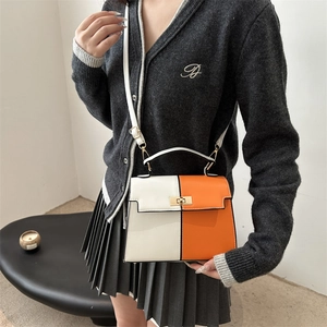 Sac à bandoulière minimaliste en cuir blanc et orange avec fermoir doré sur modèle
