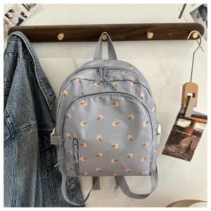 Detail of light blue floral backpack with waterproof nylon fabric and multiple pockets
