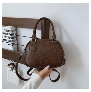 Detail of vintage brown bowling bag featuring embossed text and silver hardware
