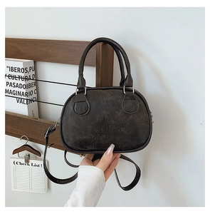 Detail of vintage dark brown faux leather bowling bag with embossed lettering and top handles