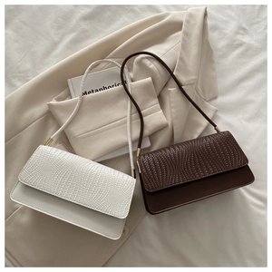 Detail of woven texture and smooth leather finish on contrast flap shoulder bags