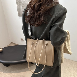 Borsa tote beige trapuntata con tracolla pied-de-poule abbinata a un blazer di velluto