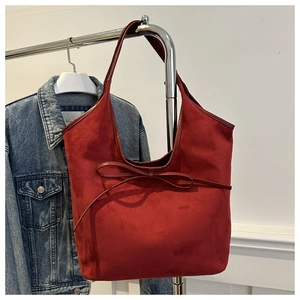 Détail du sac cabas rétro rouge bordeaux avec un nœud décoratif et une finition givrée