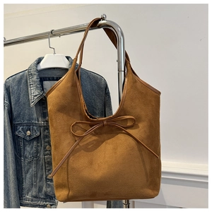 Vue détaillée du sac cabas en daim marron foncé avec un nœud décoratif et des coutures