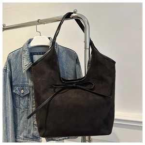 Détail du grand sac cabas en daim noir mat avec nœud papillon et design élégant chic