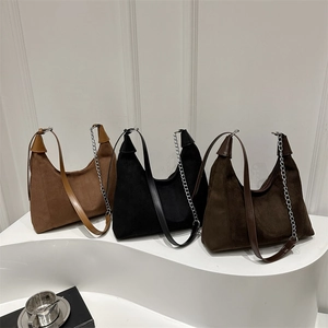 Three minimalist soft suede hobo bags in brown, black, and tan with metal chain straps