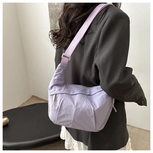 Detail view of lavender nylon crescent bag with adjustable wide strap on model
