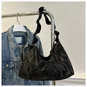 Detail of black ripple textured tote bag featuring a trendy pleated scrunchie handle style