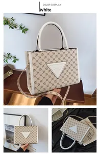 Close-up of a white monogram tote bag with triangle logo and stylish leather handle