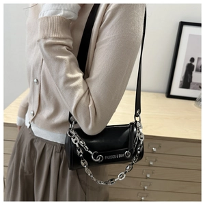 Détail du sac polochon en cuir noir avec chaîne argentée et gravure Fashion & BMH