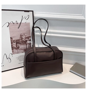Détail macro du sac cabas en cuir synthétique marron foncé avec grande poche et fermeture