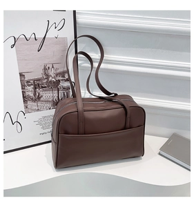 Gros plan détaillé du sac cabas en cuir mat marron foncé avec de longues anses