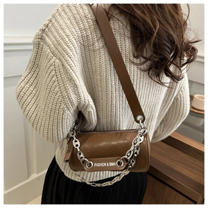 Detail showing brown pillow bag texture with silver chain and FASHION & BMH label