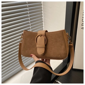 Detail of vintage brown suede shoulder bag with oval metal clasp and smooth leather trim