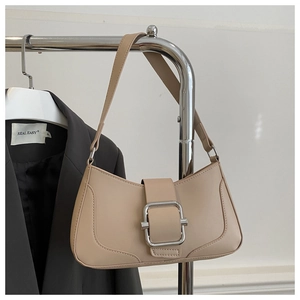 Détail du sac baguette beige avec sa grande boucle argentée et sa fine bandoulière en cuir