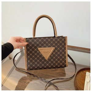 Detail of vintage brown monogram tote bag with leather bag patch and hand strap
