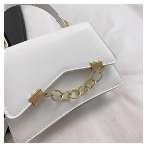 Detail of white leather flap bag featuring V-cut design and chunky gold chain decoration