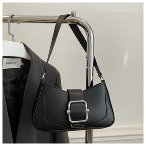 Détail du sac sous le bras en cuir noir mat avec une boucle carrée en métal argenté