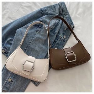 Detail of elegant French style shoulder bags with silver metal buckle on denim fabric