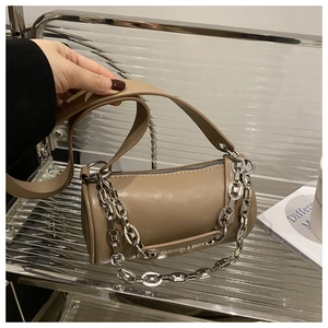 Détail d'un sac à bandoulière cylindrique marron avec chaîne argentée et similicuir