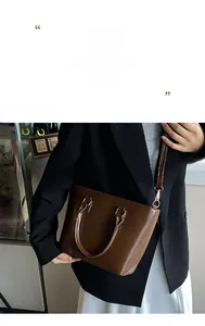 Detail of a shiny dark brown bucket bag with polished finish and adjustable strap