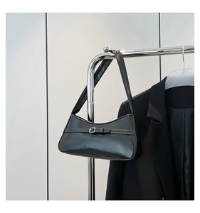 Close-up of a minimalist black PU leather shoulder bag with a silver square buckle