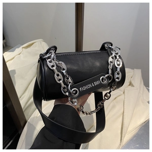 Détail d'un sac bandoulière cylindrique noir en similicuir avec chaîne argentée