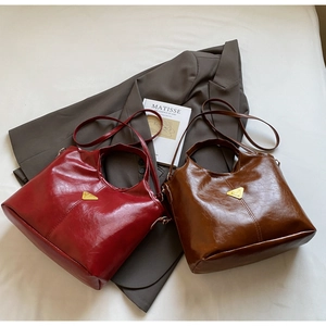 Flat lay of vintage PU leather tote bags in red and brown with metal triangle logo