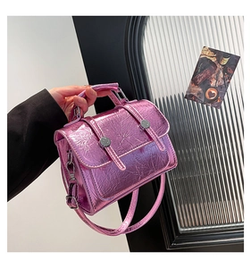 Detail of metallic purple crossbody bag with pleated texture and silver buckles