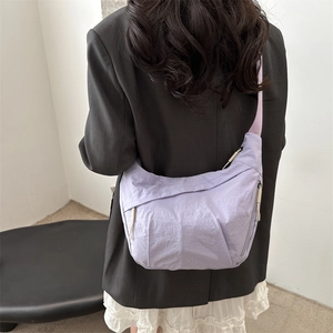 Light purple oversized nylon crescent crossbody bag styled with casual black blazer