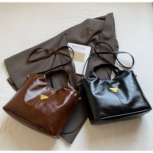 Detailed close-up of brown and black leather bucket bags with gold triangle hardware